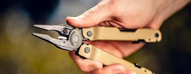 A hand holding the Leatherman 300 in Coyote Brown